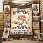 personalized book never underestimate an old lady who loves reading and was born in december quilt
